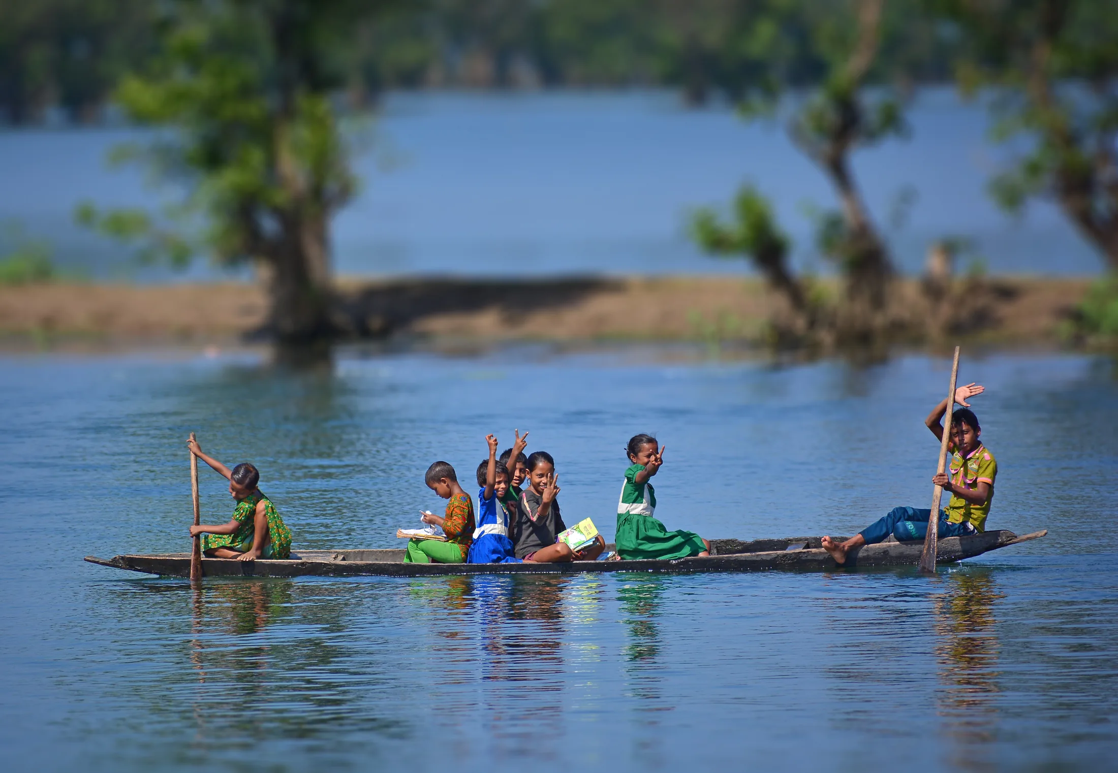 Schoolchildren crossing a river by boat in Ratargul, Bangladesh