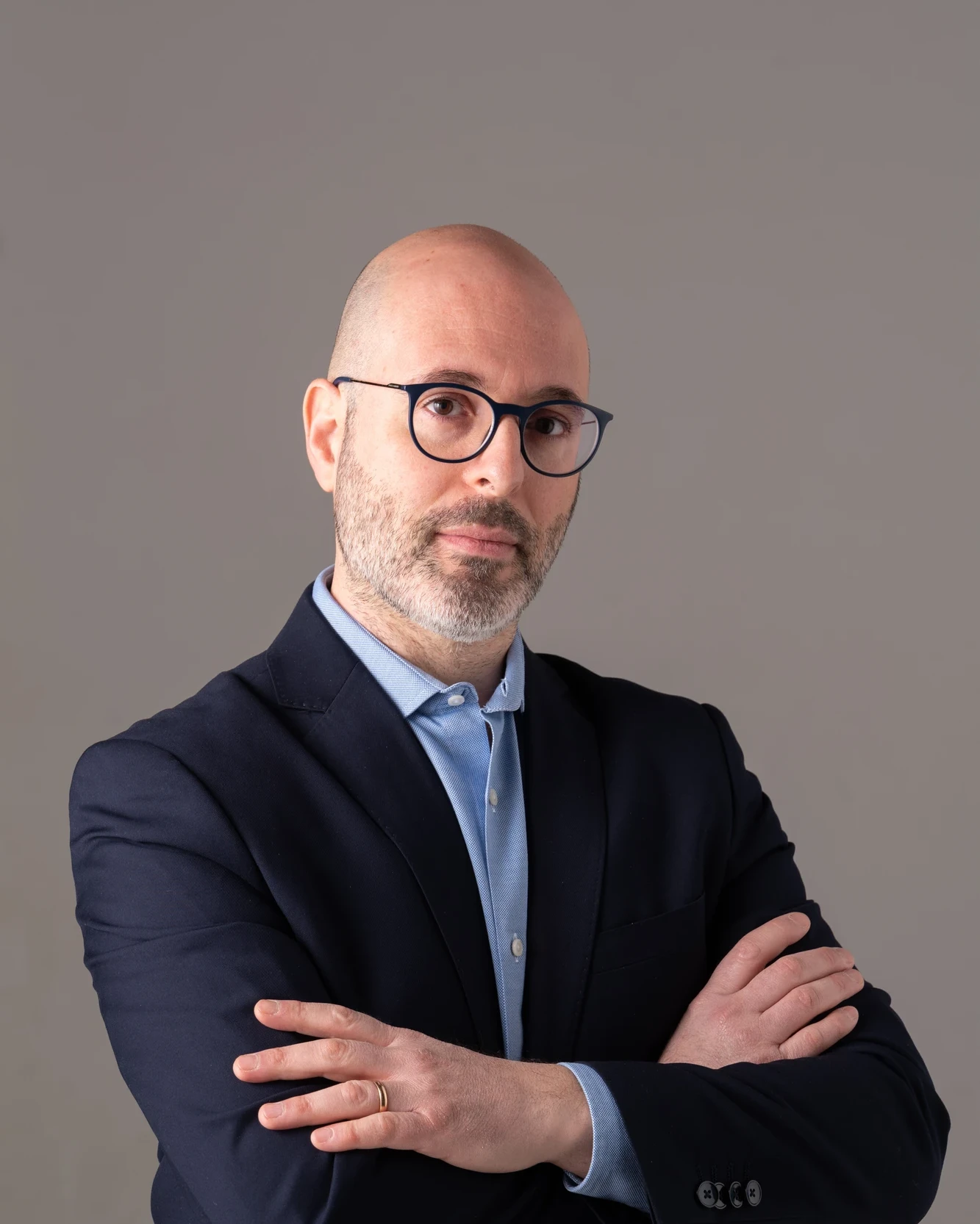 Executive headshot before editorial retouching, with a light gray background
