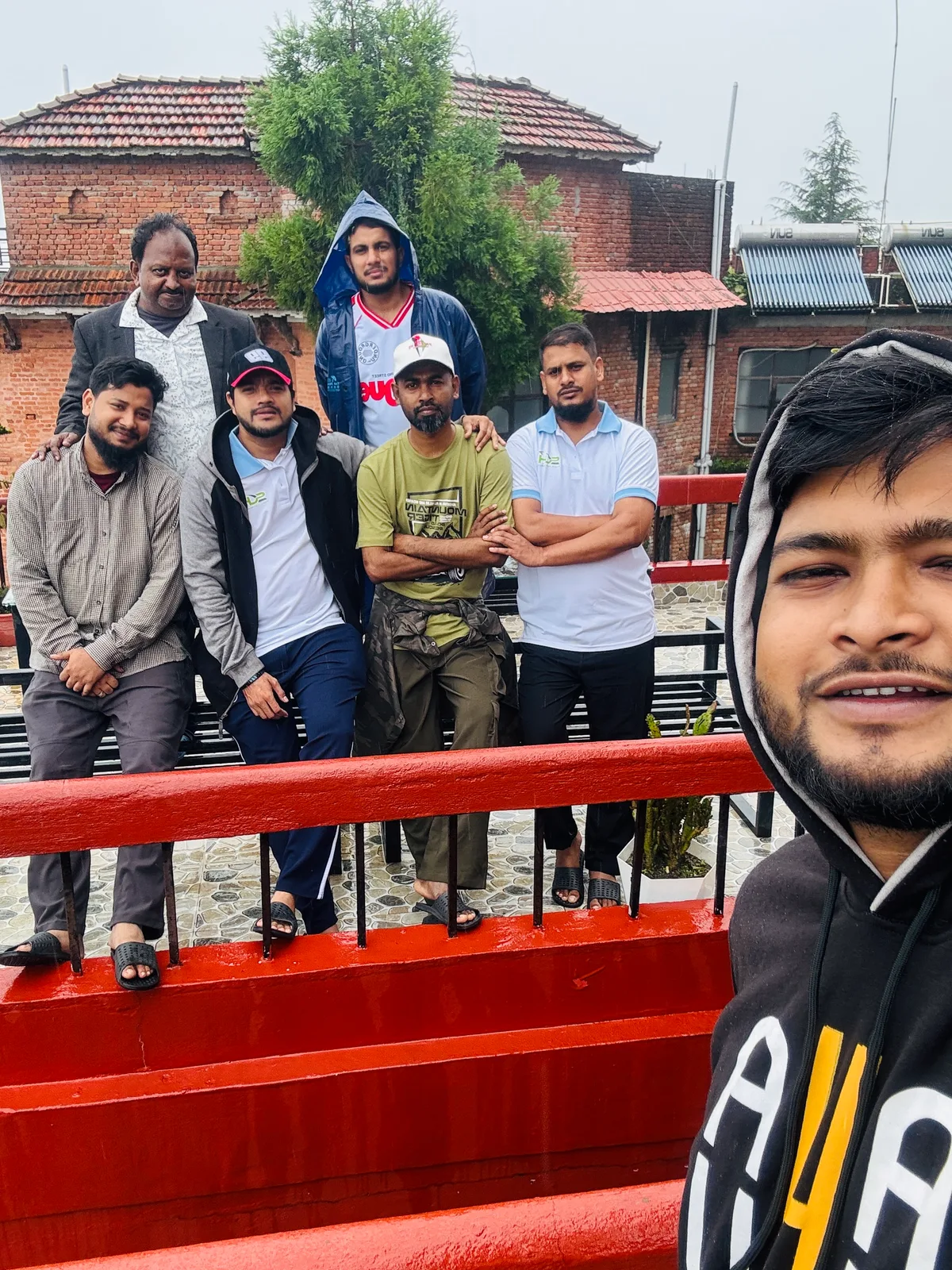 Studio Click House colleagues rooftop terrace selfie against Kathmandu cityscape