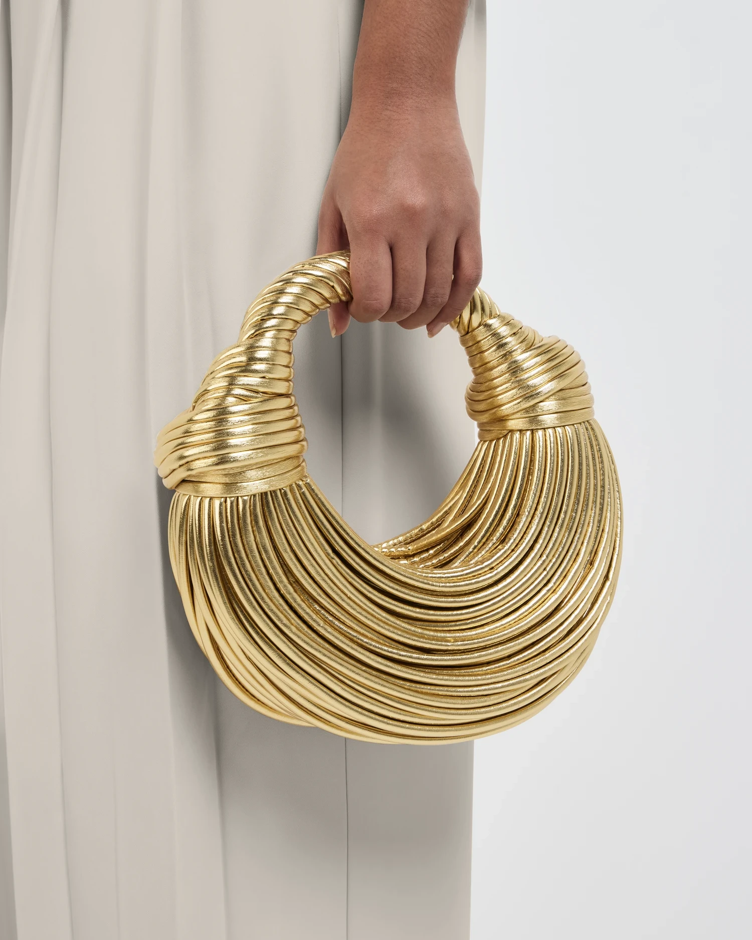 Metallic gold handbag photographed against a clean studio background