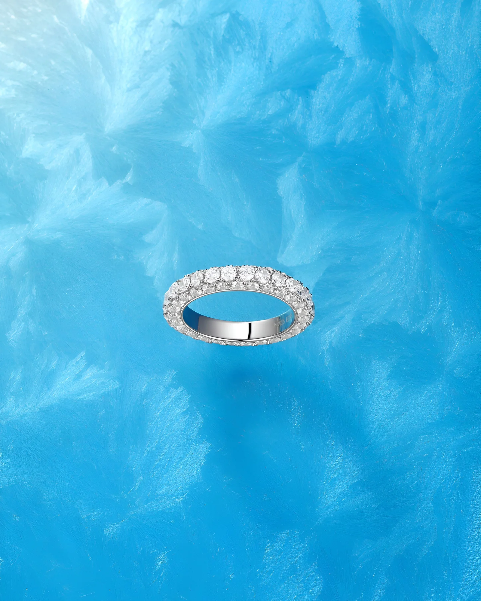 Diamond eternity band photographed against a blue water setting